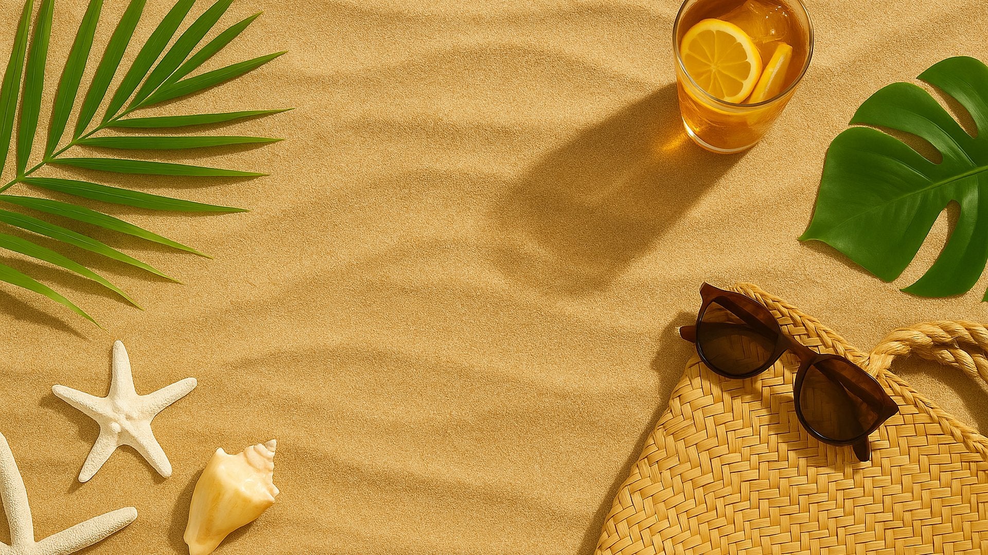 Summer-themed arrangement with a glass of iced tea, sunglasses, straw bag, starfish, and leaves on sand.